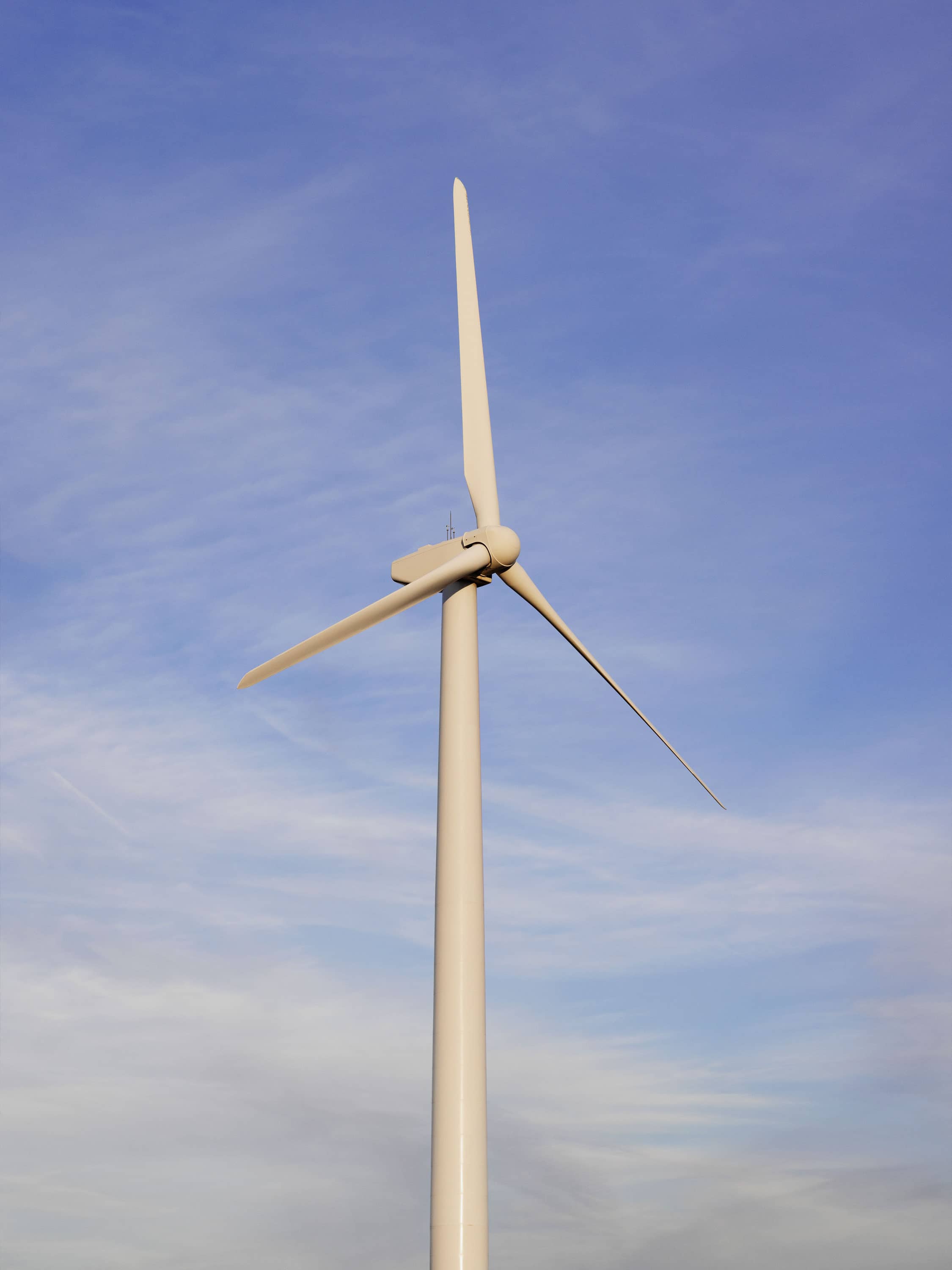 A wind turbine against a clouded sky